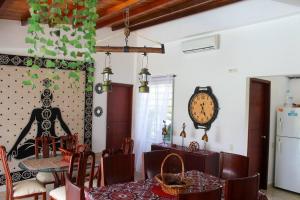 una sala da pranzo con tavolo e orologio sul muro di CASA MERAK - Inspira tu vida a Oiba