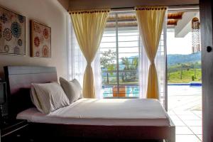 una camera con un letto e una grande finestra di CASA MERAK - Inspira tu vida a Oiba