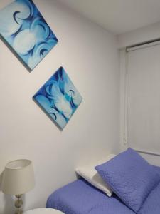 a bedroom with a purple bed and two pictures on the wall at Natural Getaway in Bogotá