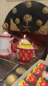 a table topped with a candle and a tea pot at شالية السحاب in Al Ḩazm