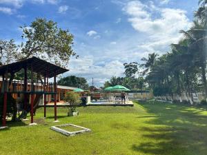 a park with a playground with a pavilion and a building at Pousada Geres Peruíbe in Peruíbe