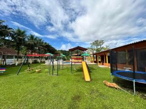 um parque com um parque infantil com escorrega e baloiços em Pousada Geres Peruíbe em Peruíbe