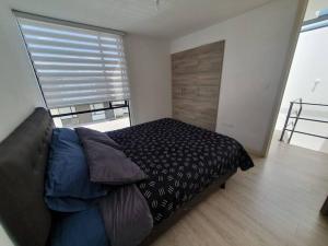 a bedroom with a bed and a large window at Casa El Rincón del Sol in Quito