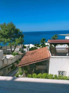 a building with a red roof next to the ocean at Una prua sul mare in Nardò