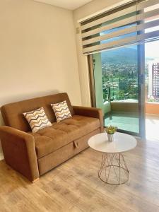 sala de estar con sofá marrón y mesa en Lujo & Vista soñada en Cocha, en Cochabamba