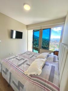 a bedroom with a large bed with a large window at Lujo & Vista soñada en Cocha in Cochabamba