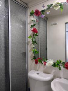a bathroom with a toilet with flowers on the wall at Natural Getaway in Bogotá