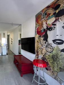 a living room with a large painting on the wall at Residence PORT NATURE by 8-HOMES vue Port in Cap d'Agde
