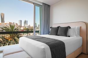 a bedroom with a white bed and a large window at Casa Cibeles by Lumina in Mexico City