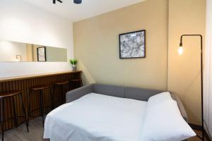 a bedroom with a white bed and a bar at Apto 1 quarto, Centro, Cambuí, Guanabara, 1 vaga garagem, prox. a mercado, academia, hospital in Campinas