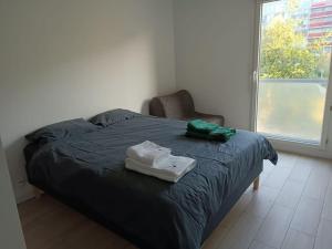 a bedroom with a bed and a chair and a window at PARIS La Défense Appt 3 Pièces in Nanterre