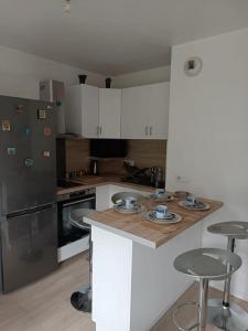 a kitchen with a counter and some stools in it at PARIS La Défense Appt 3 Pièces in Nanterre