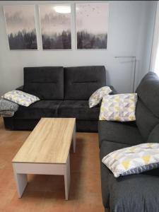 sala de estar con sofá y mesa de centro en Apartamento las huellas en Arnedillo