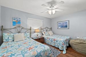 1 dormitorio con 2 camas y ventilador de techo en Commodore 1308 Free Beach Chairs With Your Rental, en Panama City Beach