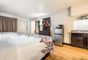 a hotel room with a bed and a kitchen at Red Roof Inn Dallas - Richardson in Dallas