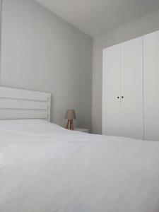 Un dormitorio blanco con una cama blanca y una lámpara en Comfort and Peace in a Luxury Residence! en Antalya