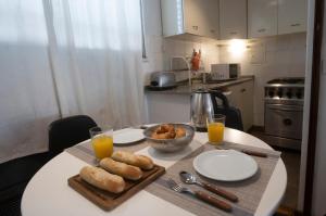 una mesa con platos de comida y vasos de zumo de naranja en Cozy Apartment in the heart of Recoleta en Buenos Aires