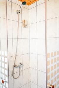 y baño con ducha y azulejos blancos. en Surf and Stay Chile, en Navidad