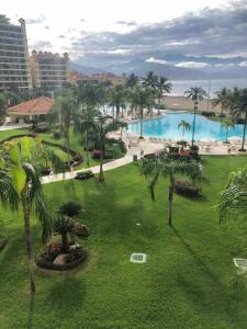 a view of a resort with a pool and palm trees at Bello departamento con vista al mar in Puerto Vallarta