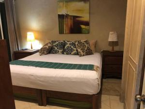 a bedroom with a bed with two tables and a lamp at Bello departamento con vista al mar in Puerto Vallarta