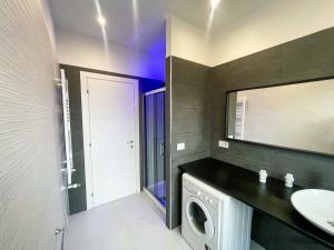 y baño con lavadora y lavamanos. en Dolce Apartments Albano, en Albano Laziale
