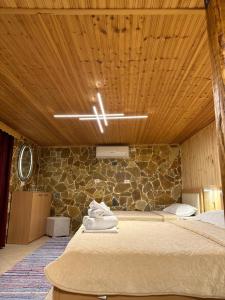 - une chambre avec un lit et un mur en pierre dans l'établissement "Mani Guest House", à Gjirokastër