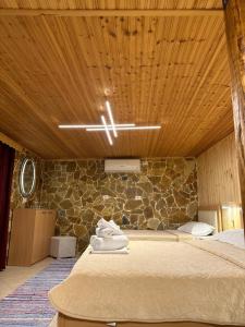 a bedroom with a bed and a stone wall at "Mani Guest House" in Gjirokastër