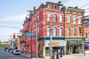 a red brick building on a city street with a traffic light at 1 Bed Apt - Amazing Location 1 Block to Carson St in Pittsburgh