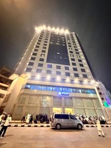 un gran edificio con una furgoneta estacionada frente a él en ALBILAD ROYA HOTEL en Makkah