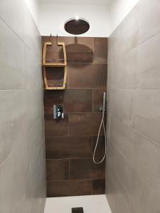 La salle de bains est pourvue d'une douche avec un tuyau. dans l'établissement Bastia Home Appartamento, à Bastia Umbra