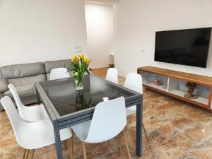 une salle à manger avec une table en verre et des chaises blanches dans l'établissement Bastia Home Appartamento, à Bastia Umbra