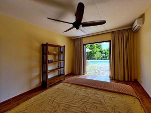 sala de estar con ventilador de techo y alfombra grande en Villa Casablanca First Floor, en Willemstad