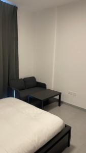 um quarto com uma cama, um sofá e uma mesa em Al jada / Reef 4 em Sharjah