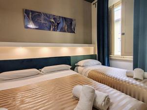 フィレンツェにあるResidenza San Lorenzo Firenzeのベッド2台が隣同士に設置された部屋です。