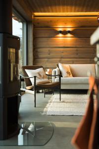 Unique Romantic Cabin with Mountain View at Strandafjellet, Mivo X في ستراندا: غرفة معيشة مع كرسيين وأريكة