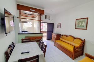 een woonkamer met een tafel en een gele bank bij Ancora Peruibe Hotel in Peruíbe