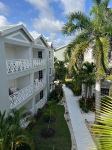 a white building with a palm tree in front of it at South Point Hotel in Christ Church