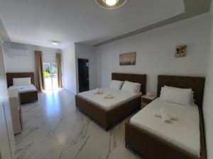 une chambre d'hôtel avec deux lits et un canapé dans l'établissement Vila Koal, à Ksamil