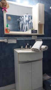 a bathroom with a white sink and a blue wall at Monte Grande Centrico in Monte Grande