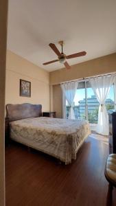 1 dormitorio con 1 cama y ventilador de techo en Monte Grande Centrico en Monte Grande