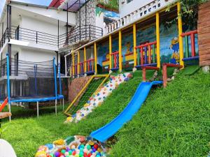 a playground in front of a building with a slide at Ecohotel Java in Manizales