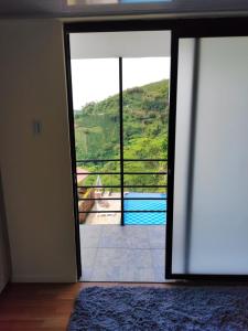 a sliding glass door with a view of a pool at Ecohotel Java in Manizales