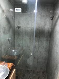 a bathroom with a glass shower with a sink at Ecohotel Java in Manizales
