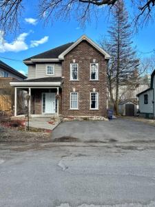 a brick house with a driveway in front of it at Magnifique maison près de l’eau in Laval