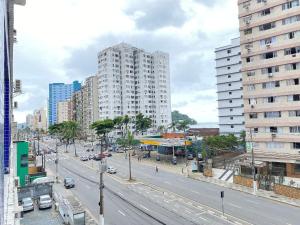 a city street with a tall white building at Pé na Areia Praia do Gonzaguinha in São Vicente +16 photos
