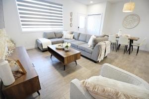 sala de estar con sofá y mesa en BoHo Retreat with King Beds, Golf, Disney+, Near WEM en Edmonton