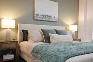 um quarto com uma cama com almofadas e 2 candeeiros em BoHo Retreat with King Beds, Golf, Disney+, Near WEM em Edmonton