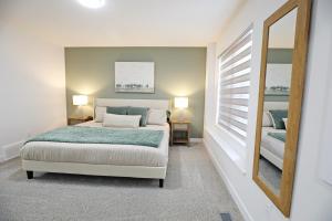 1 dormitorio con cama y espejo en BoHo Retreat with King Beds, Golf, Disney+, Near WEM en Edmonton
