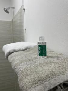 a glass bottle sitting on top of a towel at Habitación de descanso con aire acondicionado in Villavicencio