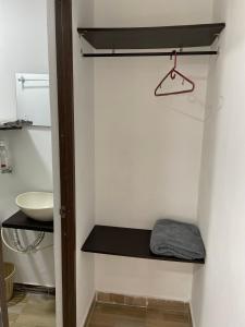 Baño pequeño con lavabo y estante en Habitación de descanso con aire acondicionado, en Villavicencio